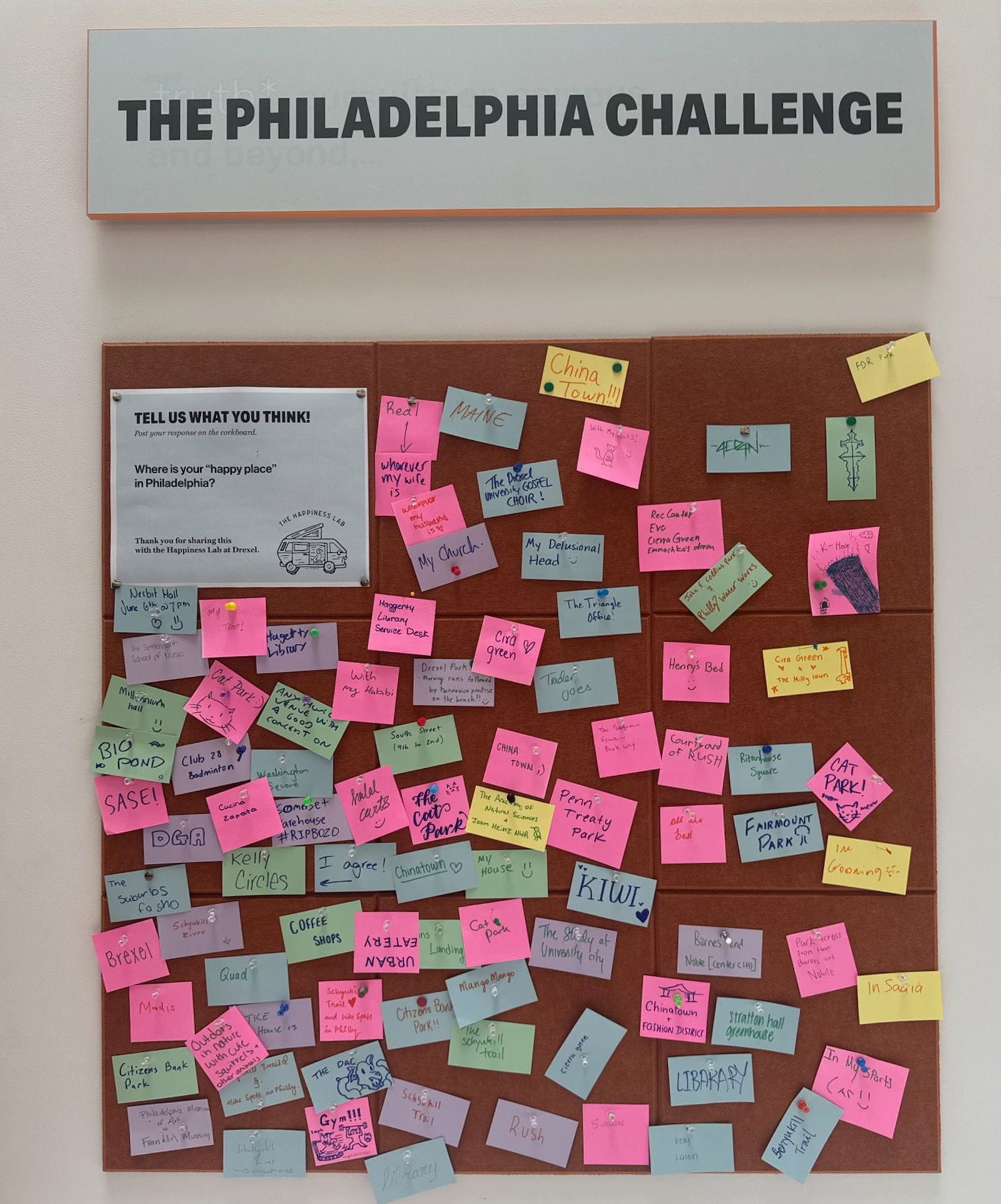 A corkboard full of colorful post-in notes uner the sign "The Philadelphia Challenge."