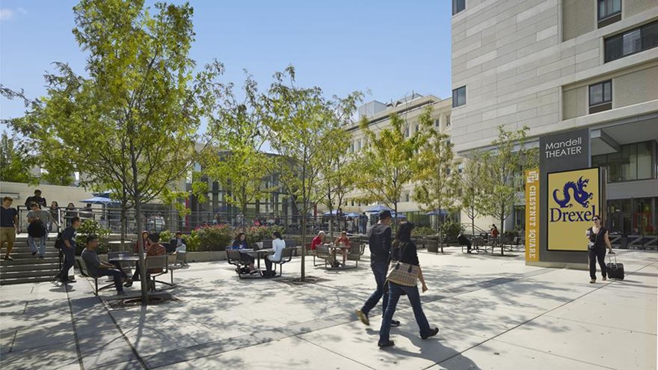 People walking outside Chestnut Square on a sunny day.