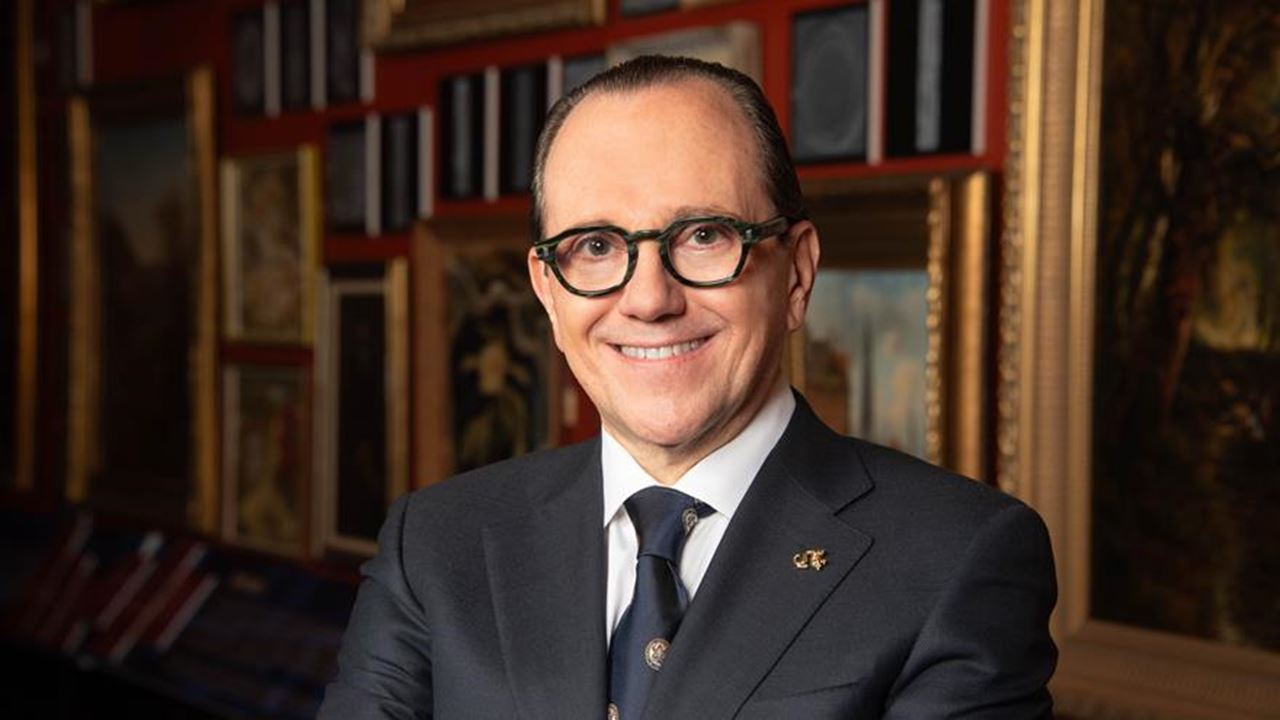 Antonio Merlo stands in front of artwork.