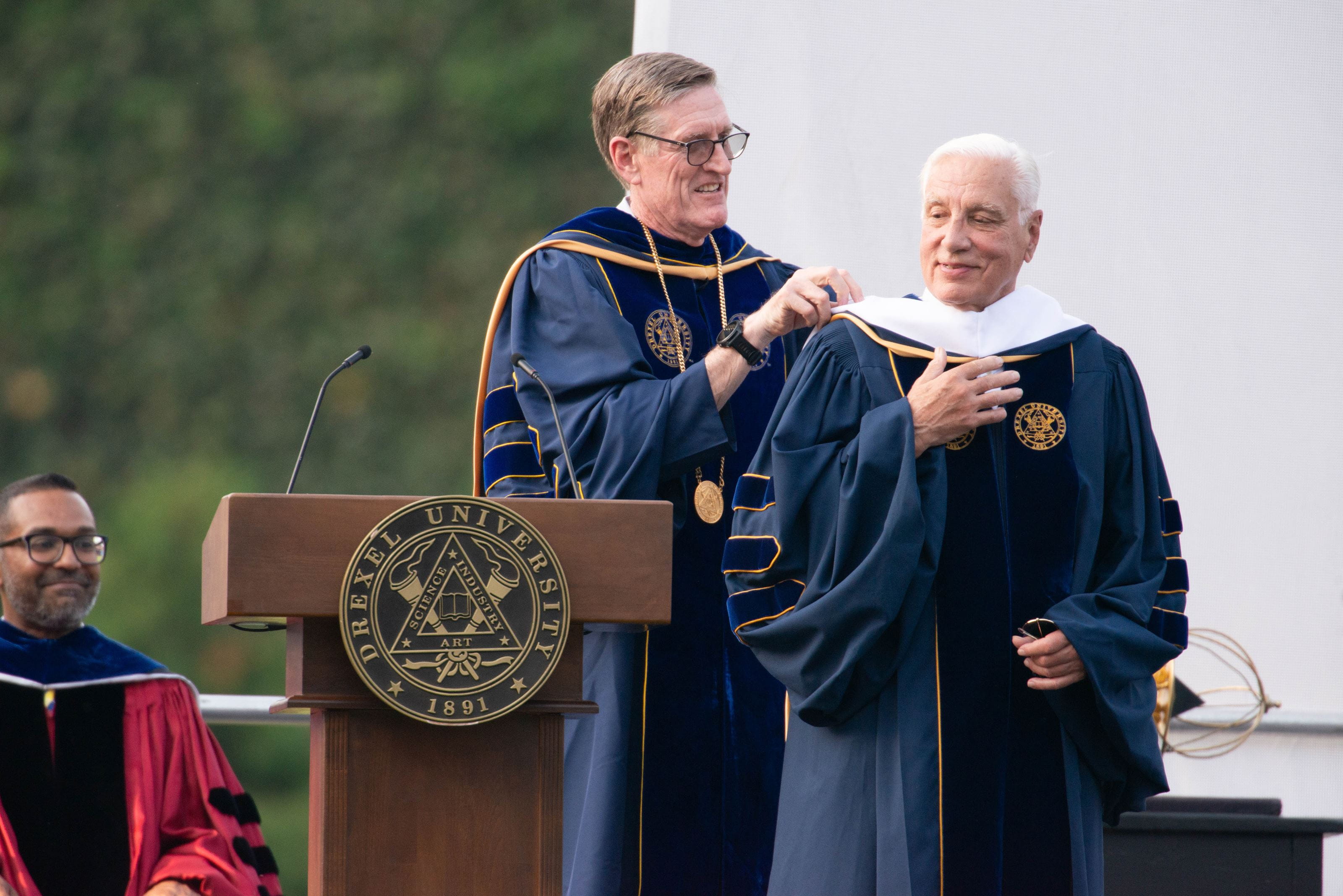 Denis O'Brien hangs regalia on Richard Greenawalt.