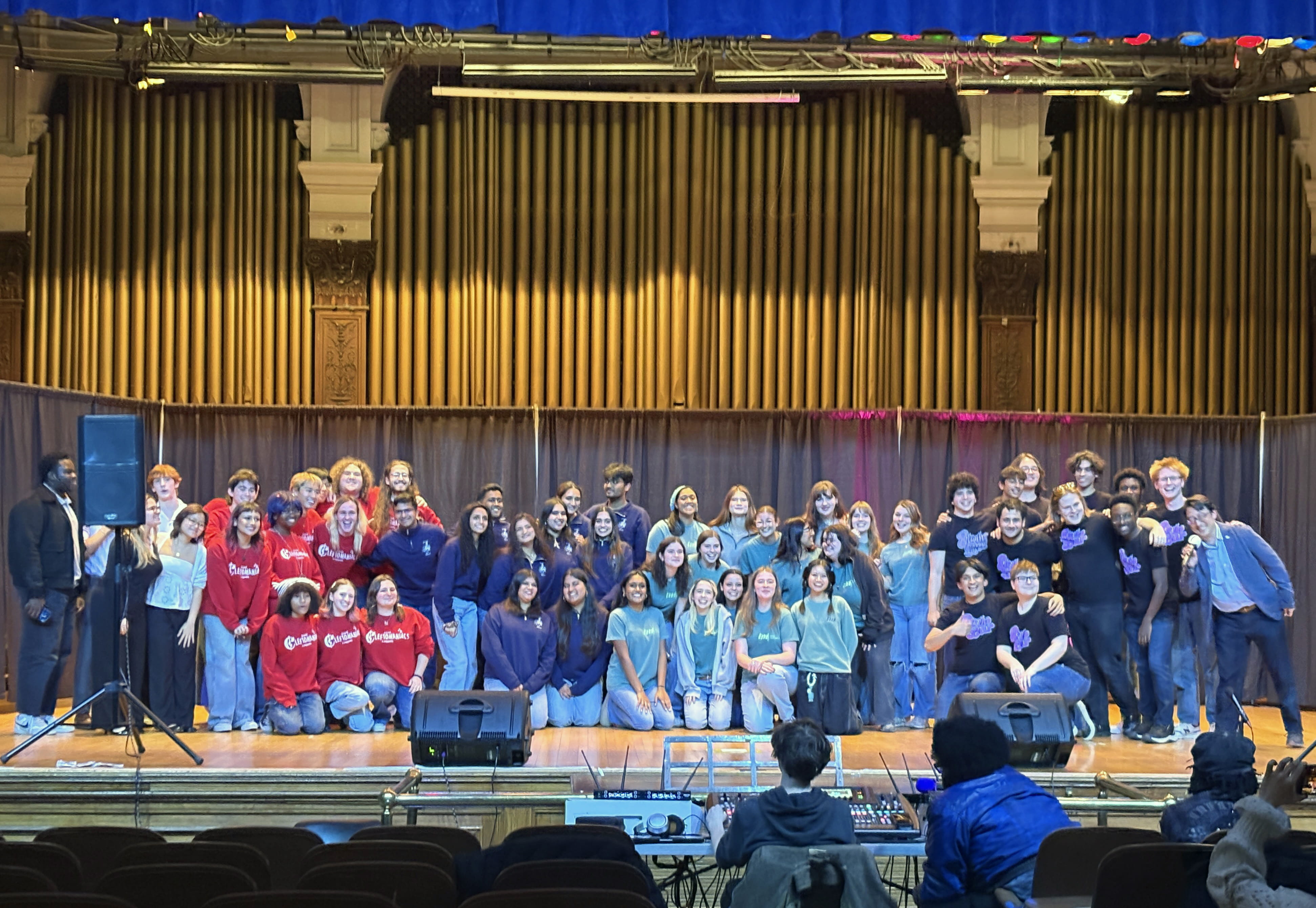 A large group of student performers standing on stage