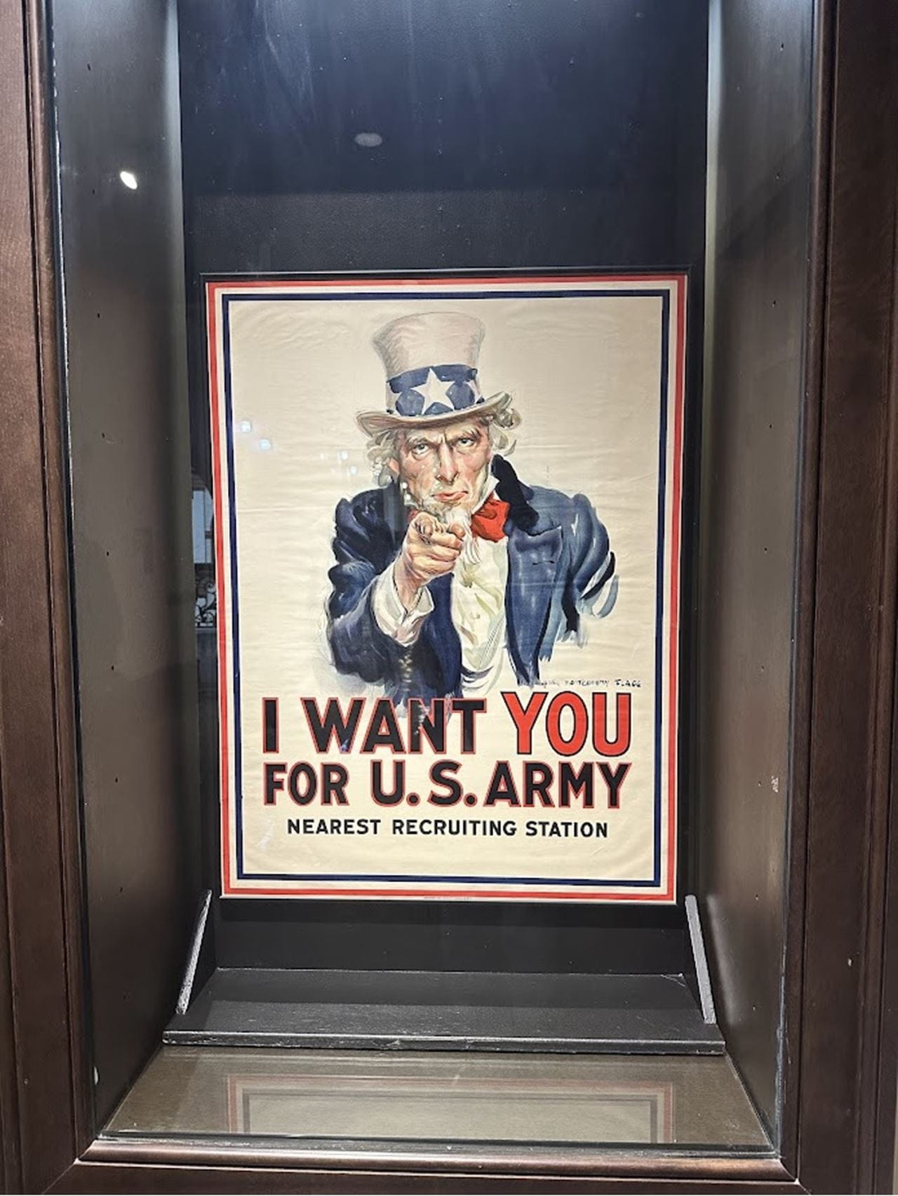 An Uncle Sam recruiting poster in a glass case.