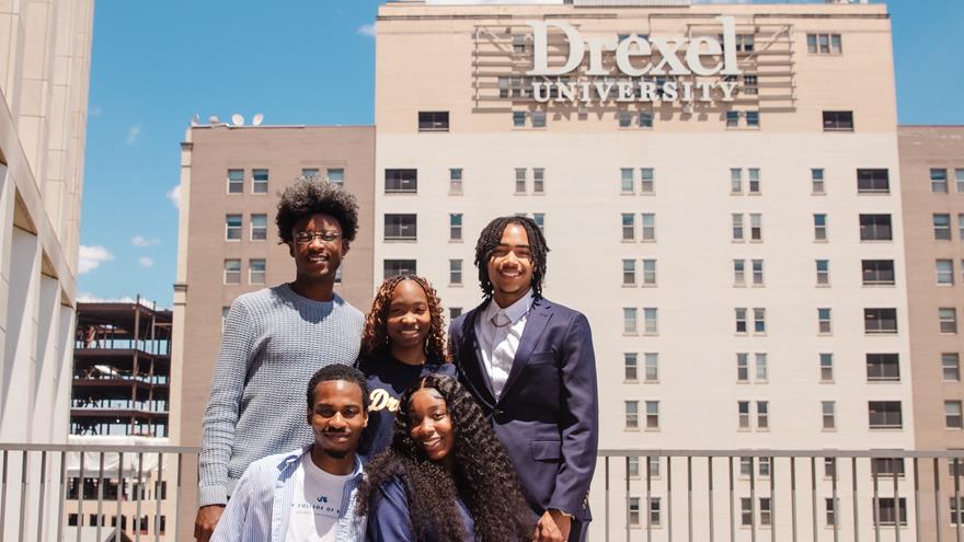 Five students in front of University Crossings