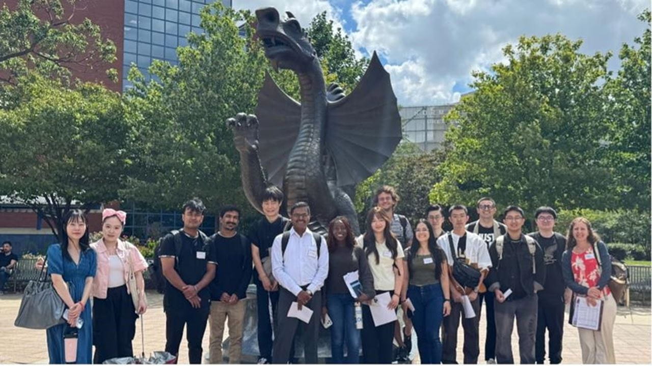 The 2025 ITA group in front of Mario the Dragon with Anne Politz, associate teaching professor in the ELC. 