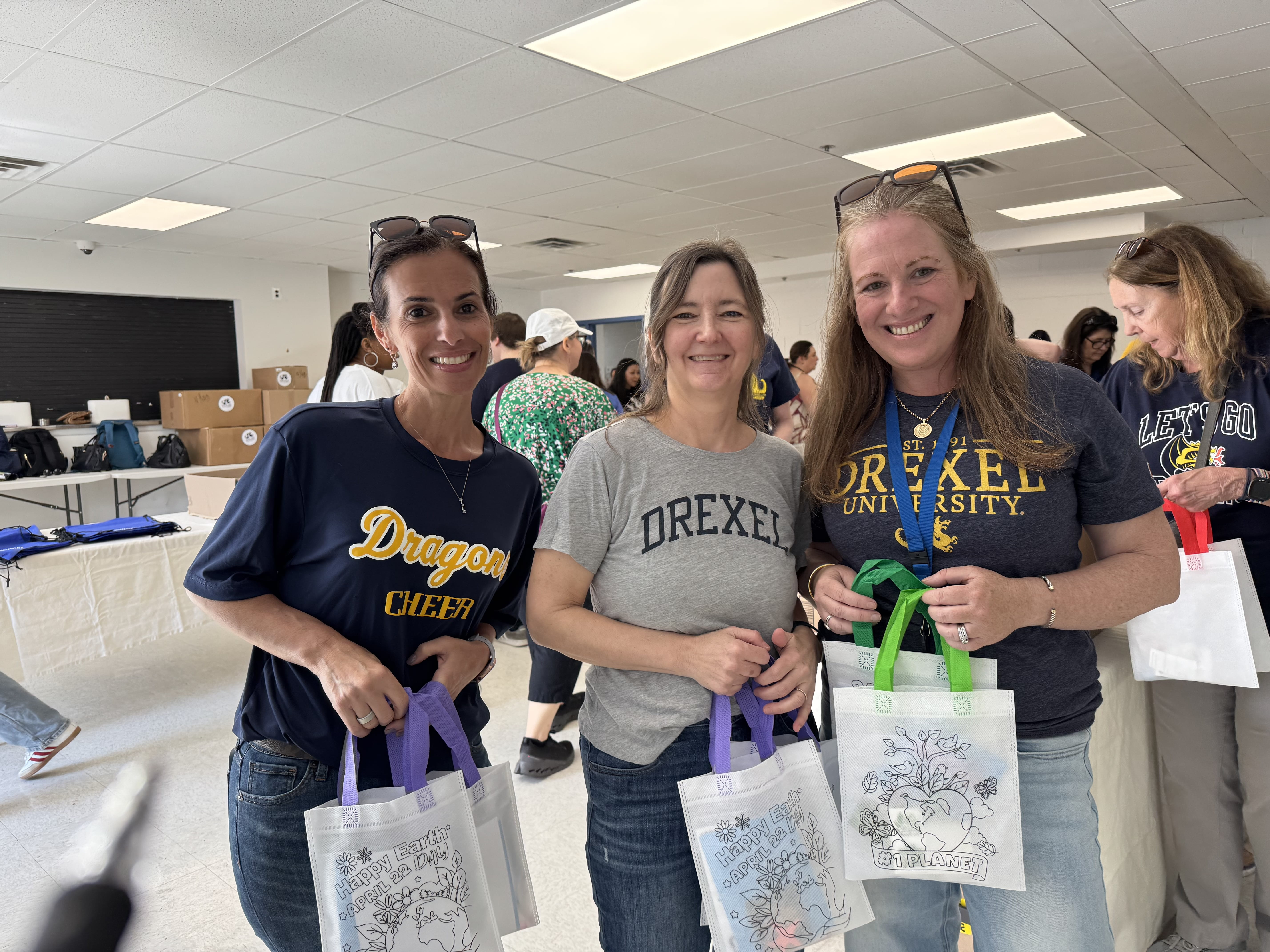 Three women pose with packed kits at Dornsife Center