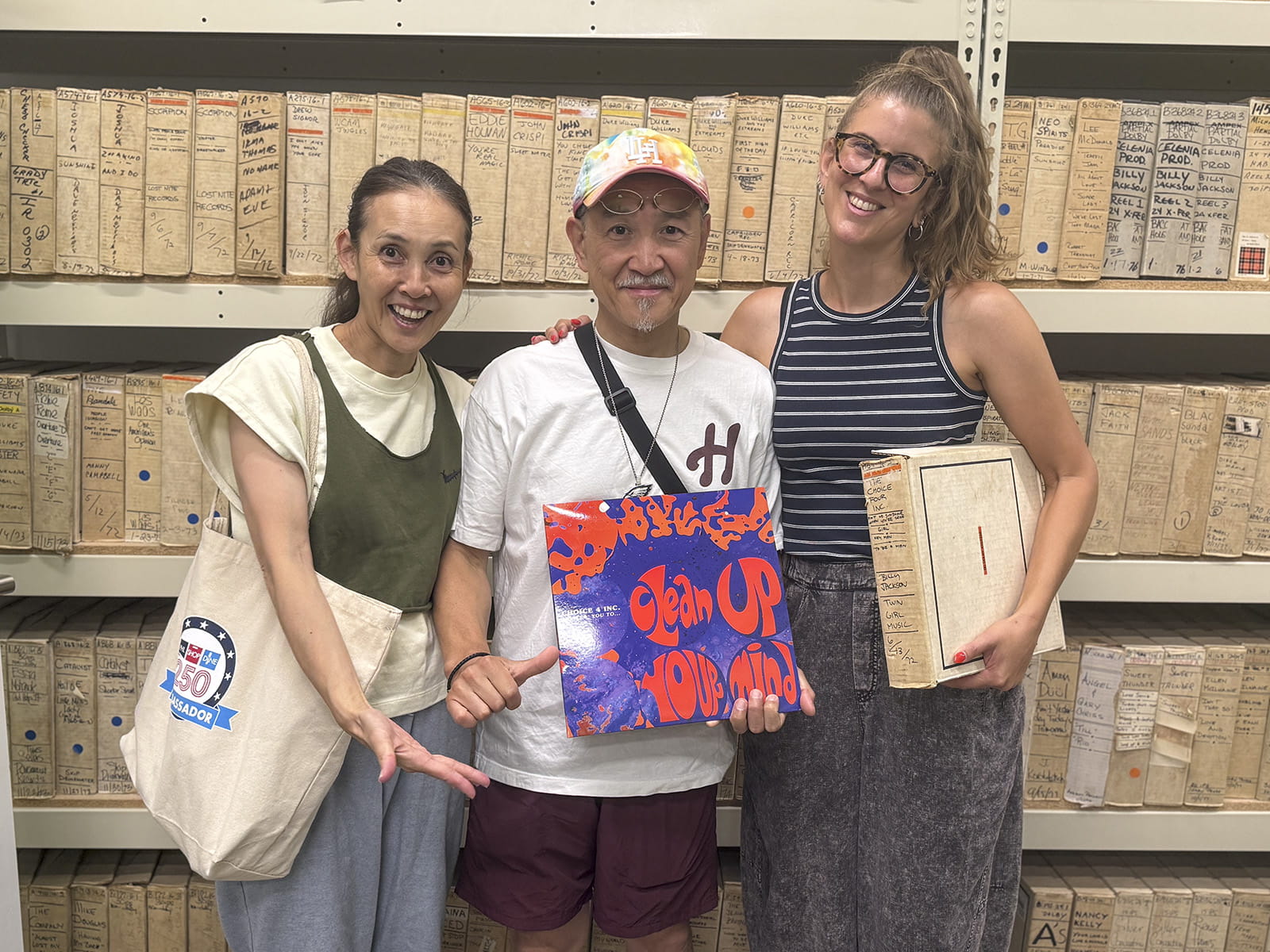 Left to right: Tomomi Chujo, Kosuke Chujo and Monika Julien in the Sigma Sound Studios Collection in the Drexel University Audio Archives. Kosuke is holding a vinyl record, “Clean Up Your Mind” by Choice 4 Inc.