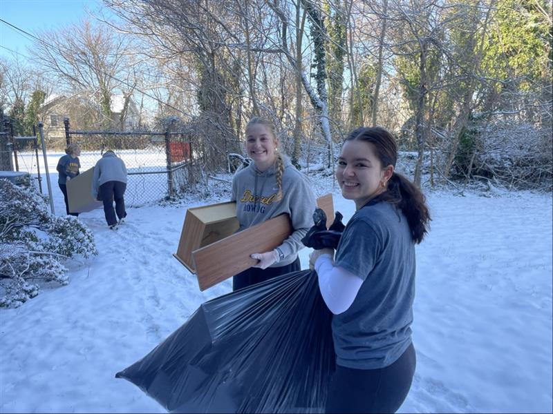 A student hauls away a bag during a cleanup event