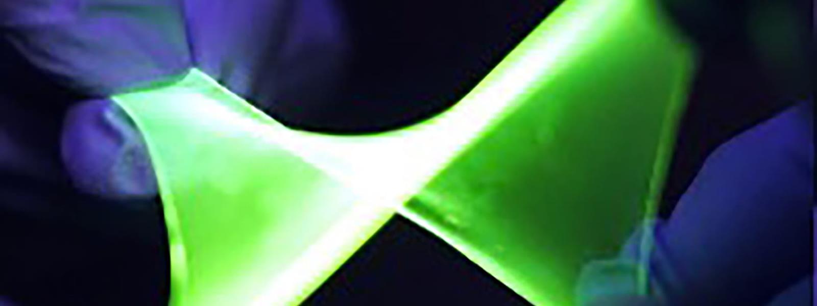 two hands stretching bright green mateiral