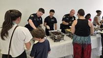 Members of the Drexel University Police Department help serve up a recent community dinner at the Dornsife Center.