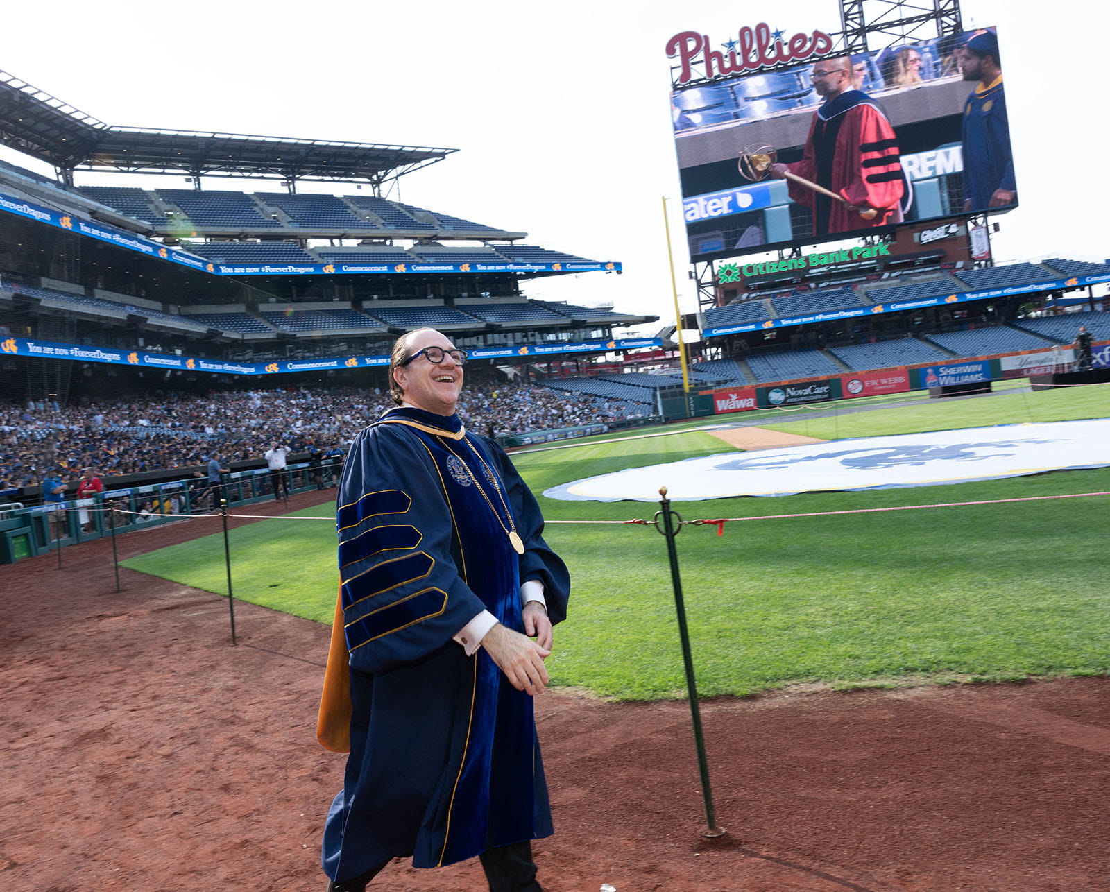 Antonio Merlo walks on the field at the Univ ersity-wide Commencement