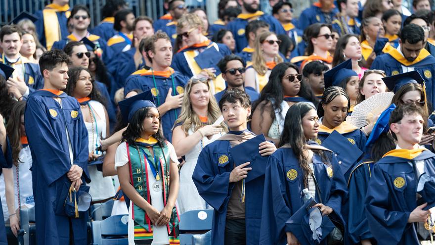 A photo of the crowd of graduates in blue Commencement gowns