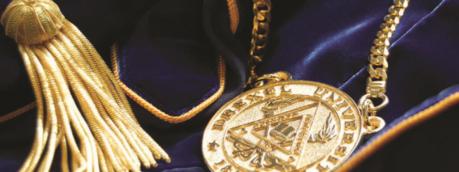A gold medallion and tassel on a blue velvet fabric.