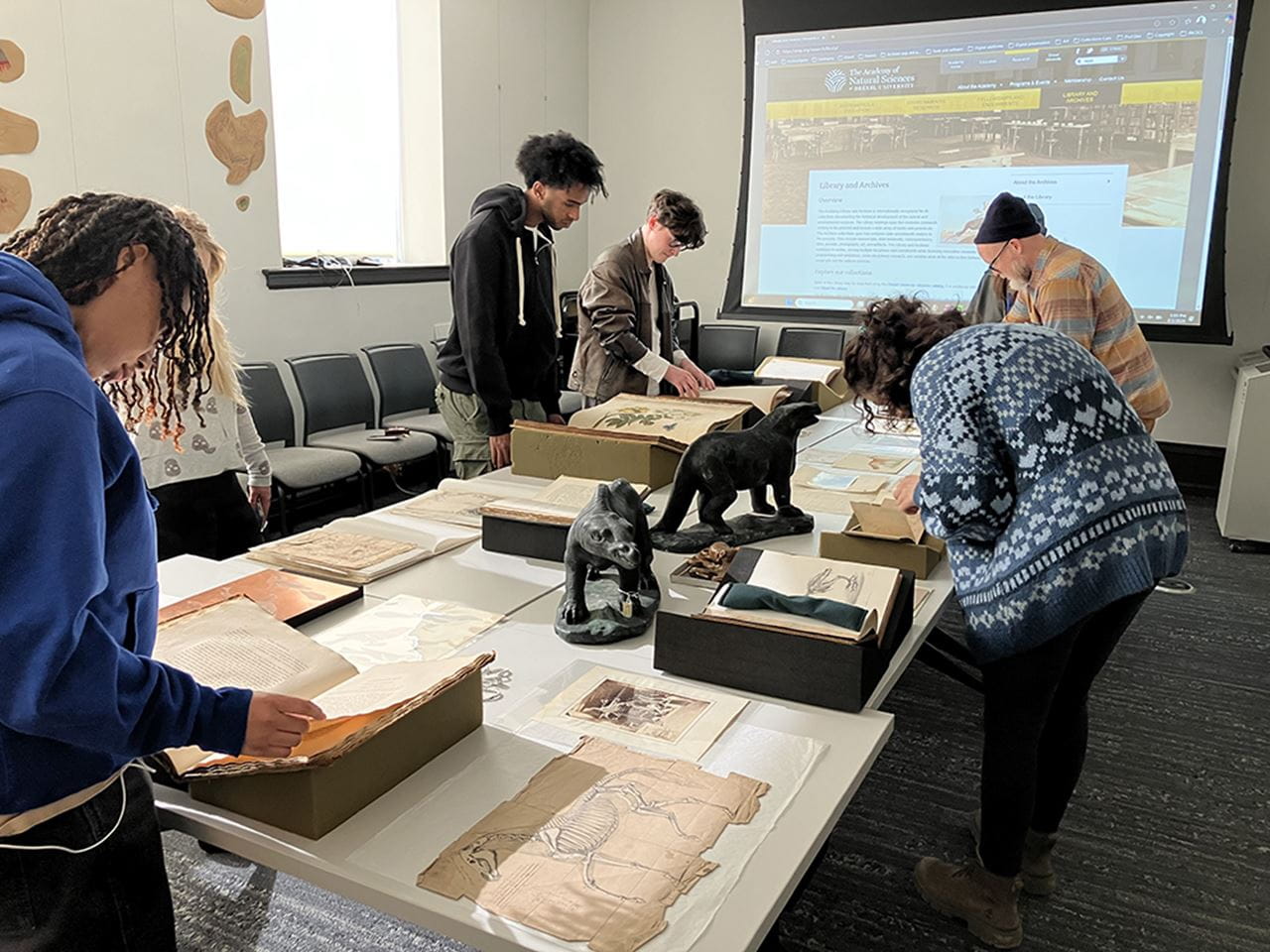 Students reviewing materials on a table.