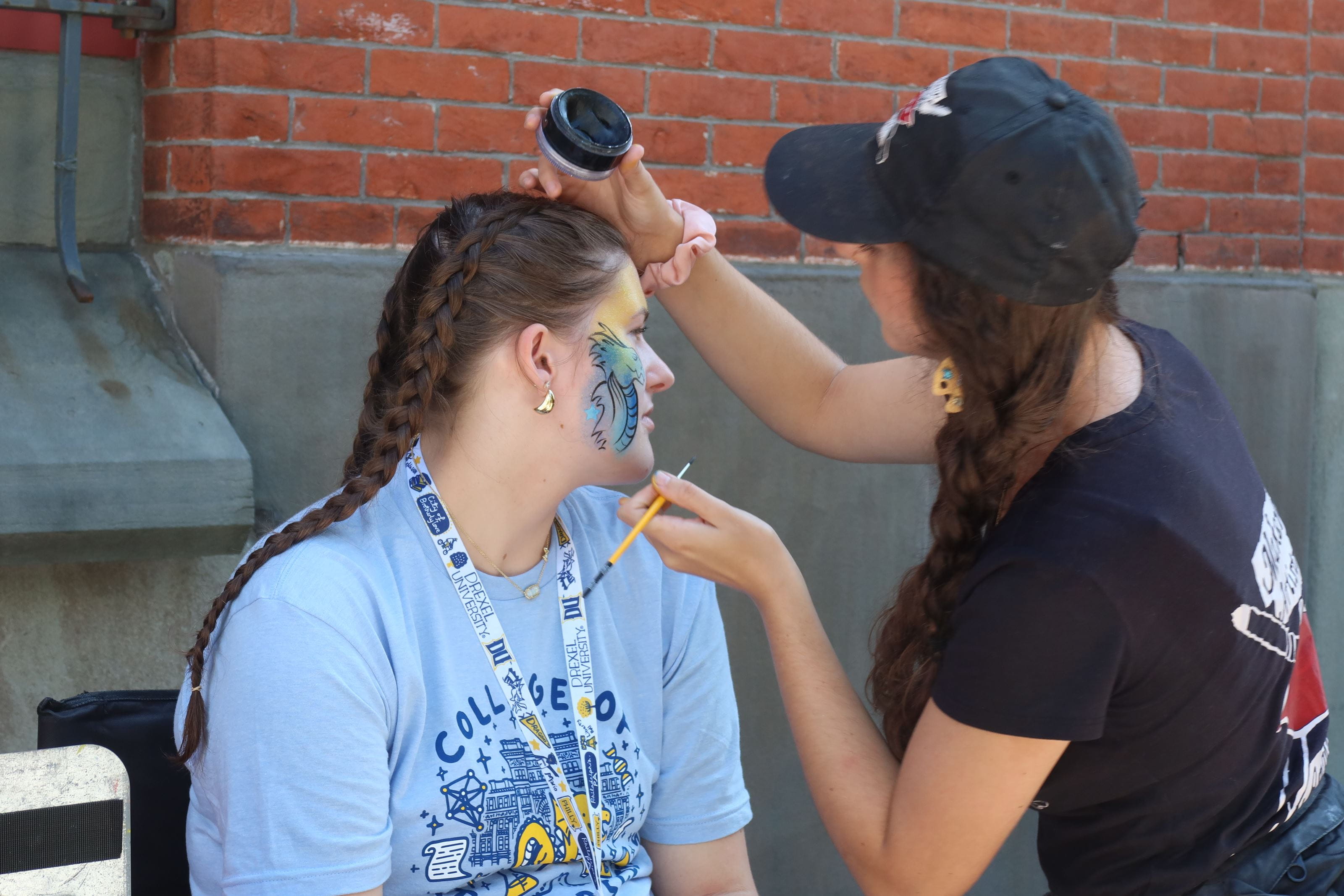 Student getting face paint at go blue gold day 
