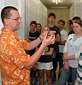 Dr. Nate Rice showing a hummingbird specimen from the Ornithology collection to visiting students