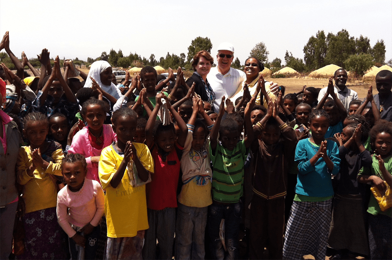 Dana and David Dornsife and Shannon Marquez, PhD, with children and friends at Kechema Water Point in Ethiopia, a World Vision WASH project site.