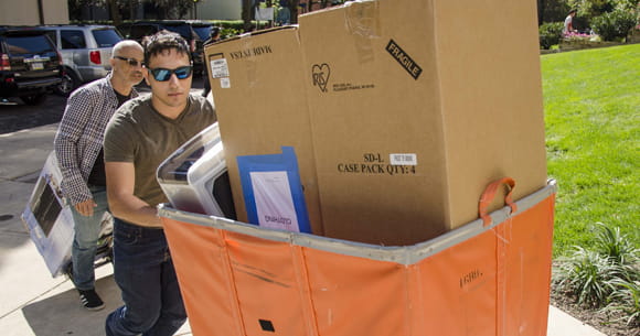 A student moving in last fall with the help of a cart.