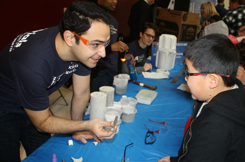 Current Drexel post-doctoral researcher, then PhD candidate Babak Anasori gives a one-on-one materials science demonstration to an interested young boy.