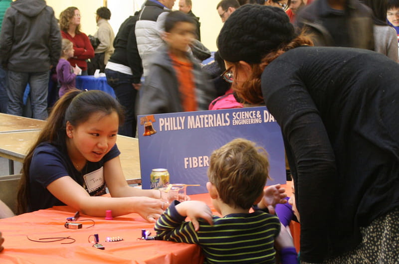 Drexel student Jing Chen demonstrates fiber optics to a young participant at the 5th annual Philly Materials Science and Engineering Day. 