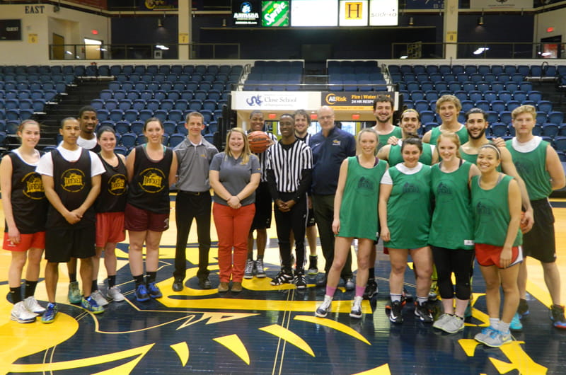 Before the intramural basketball coed championship, Drexel Director of Athletics Eric Zillmer (center, in blue shirt and glasses) was honored for his work.