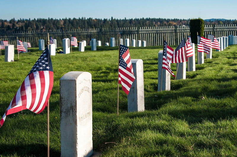 Graves of veterans decorated with flags.