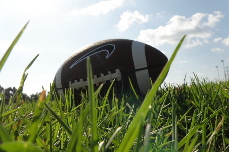 A football laying in the grass. Photo by RonAlmog (https://www.flickr.com/photos/ronalmog/3104856676/).
