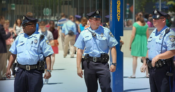 Three Drexel Police officers keep watch over a crowd