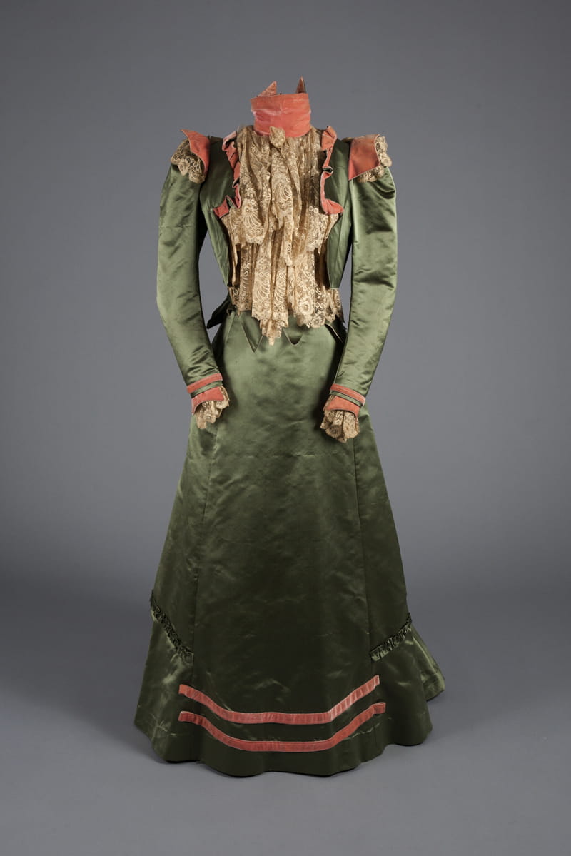 A green satin, pink velvet and lace walking dress from 1900. Gift of Mrs. James Creese.