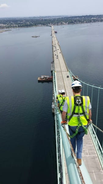 After conducting a bridge inspection, Tim Browne (mechanical engineering) walks down the cable of the Newport Bridge in Rhode Island.