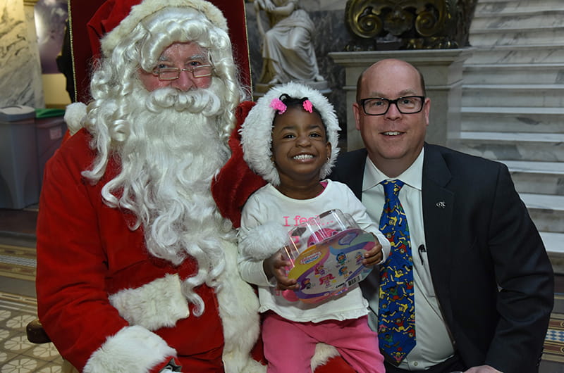 Santa Claus and Office of Government and Community Relations Senior Vice President Brian Keech met with a very excited member of the community at the Dec. 11 toy distribution ceremony.