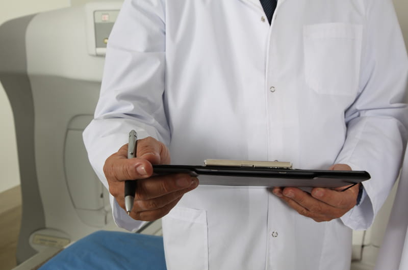 A doctor in a white coat holding a clipboard