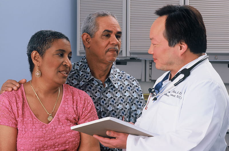 A Latino couple visiting with a physician.