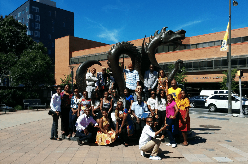 The Mandela fellows pose by Mario the Dragon.