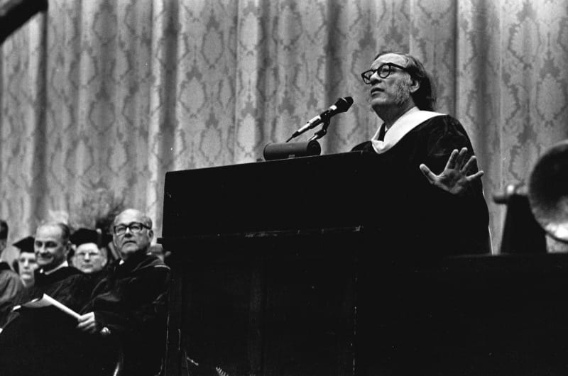 Isaac Asimov speaking at the 1976 Drexel University graduation ceremony. Drexel President William Hagerty, left of the podium, looks on. Photo courtesy University Archives.