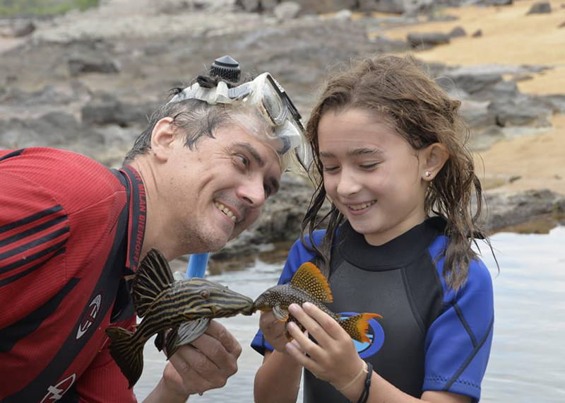 Mark Sabaj and his daughter Sofia holding fish