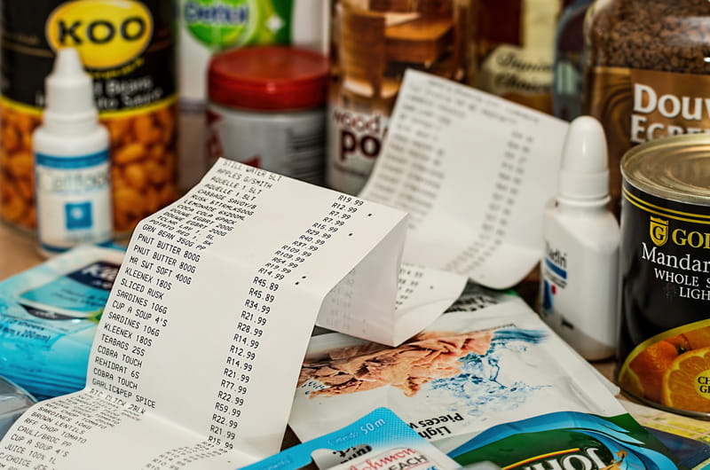 A receipt sitting on and near an assortment of groceries