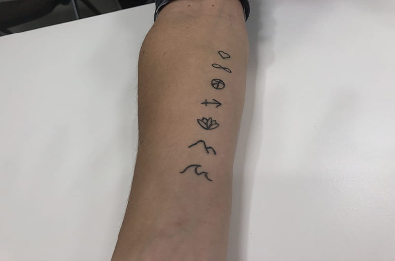 The symbols of Carreño's gods, as tattooed on her arm: love, infinity, anti-hate, Sagittarius, detachment, mountains and water. 