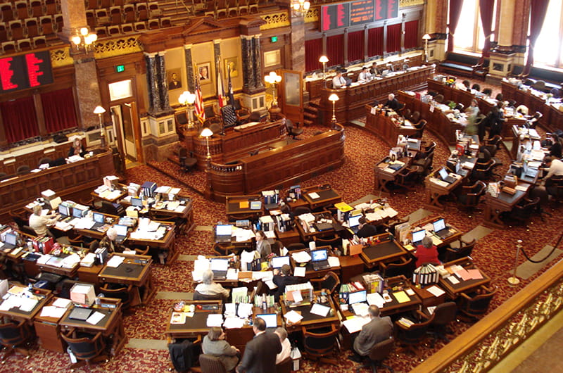 An elevated view of the Iowa State Senate with some people inside