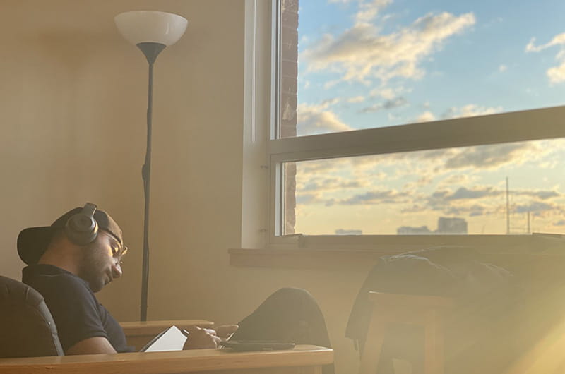 Mir Ahmed Leghari, a first-year finance student, finds solace while writing in solace in Caneris Hall this term.