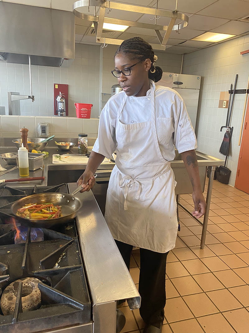 Drexel student Charmaine Patterson cooks food in the kitchen at the University. 