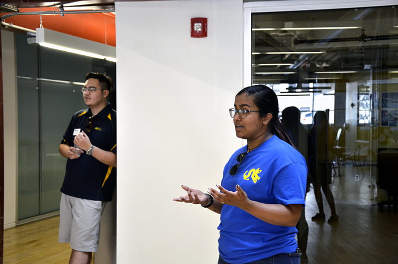 Drexel student Esta Jacob explaining that the floor of the URBN Center is made out of recycled bowling lanes during a campus tour for prospective students.