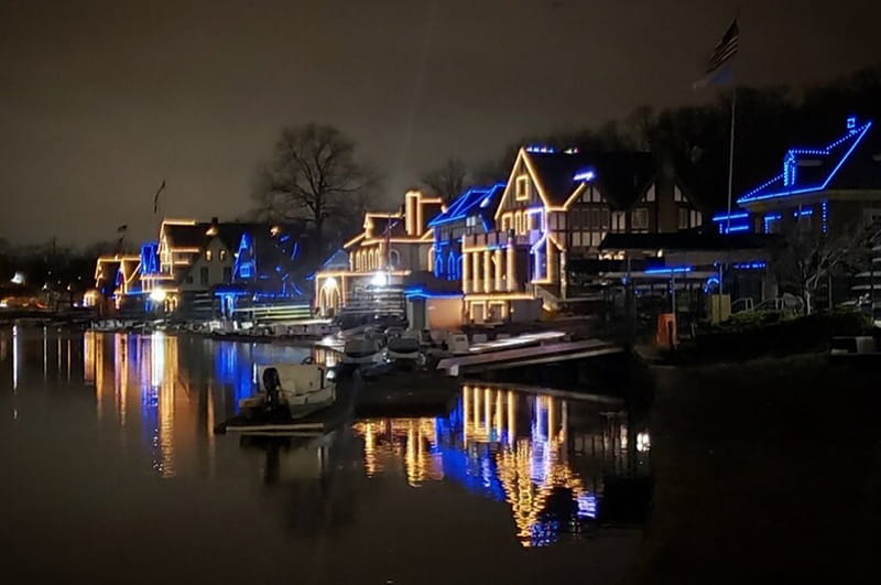 Boathouse Row lit up in blue and gold.