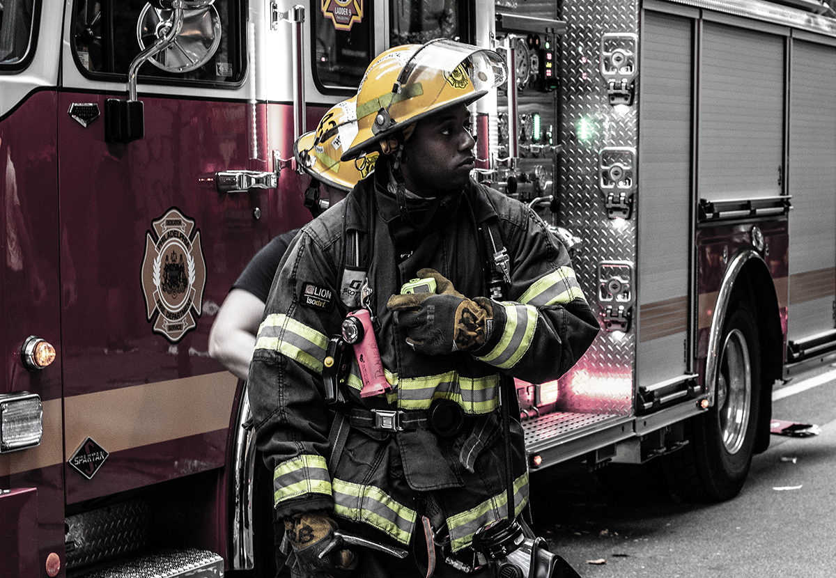 A firefighter stands in front of a fire truck.