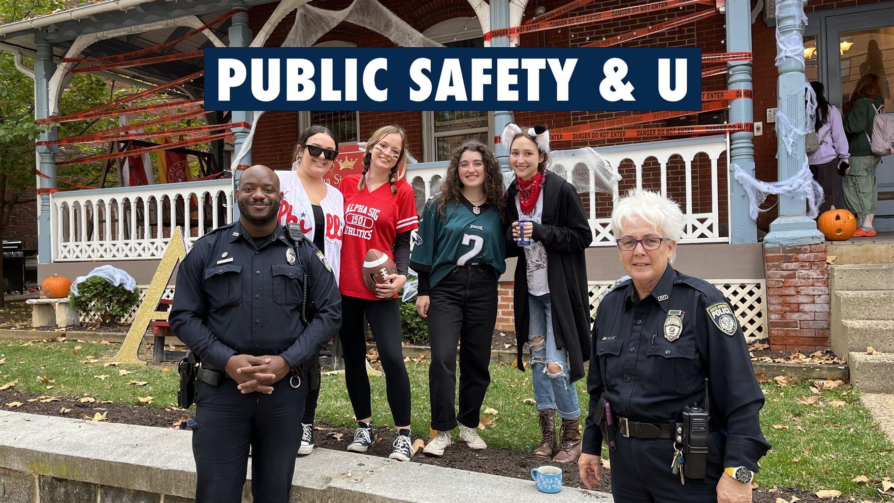 Two police officers stand with four college students dressed up for Halloween, with the text reading &quot;Public Safety &amp; U.&quot;
