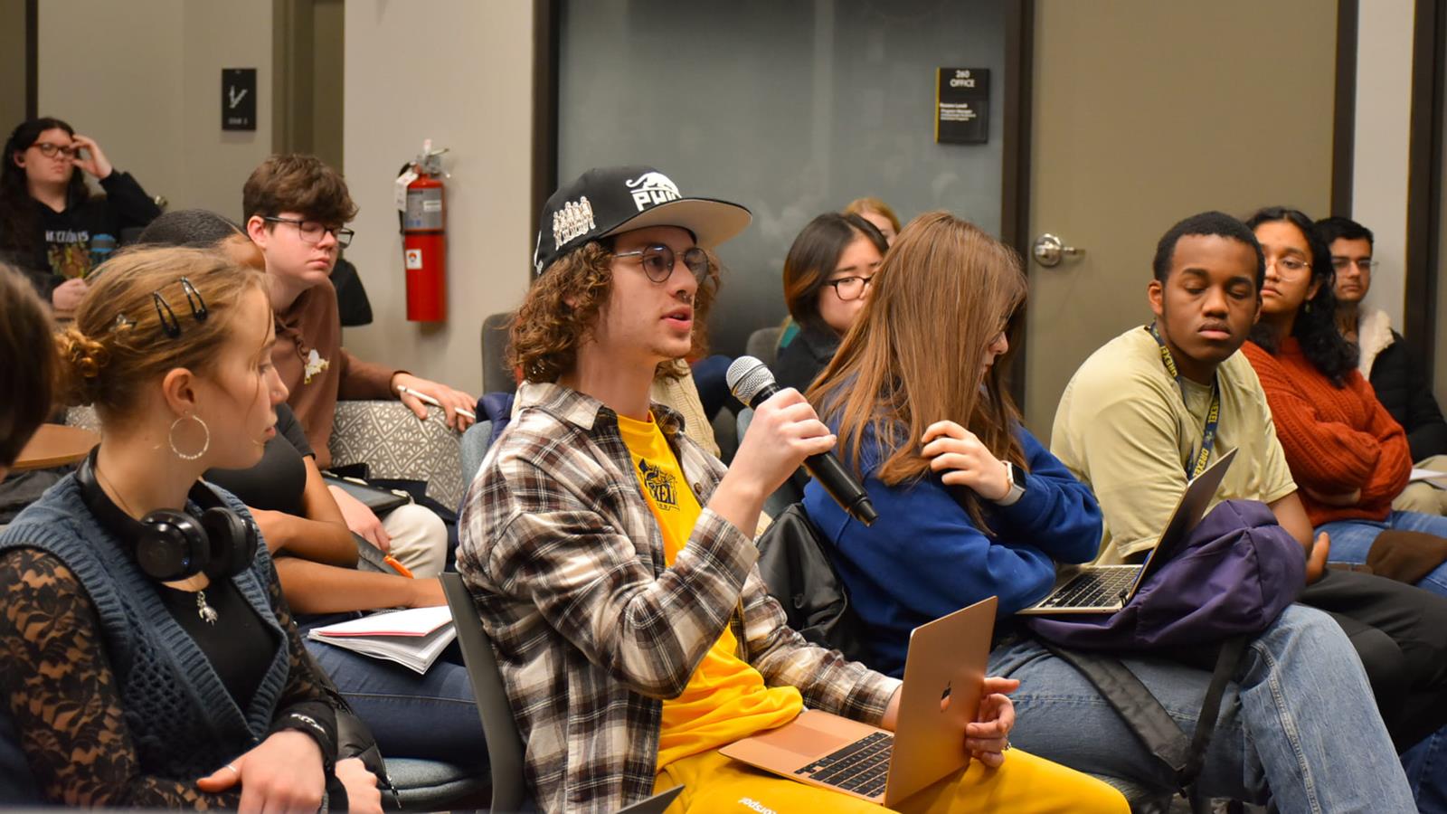 A student uses a microphone to ask a question
