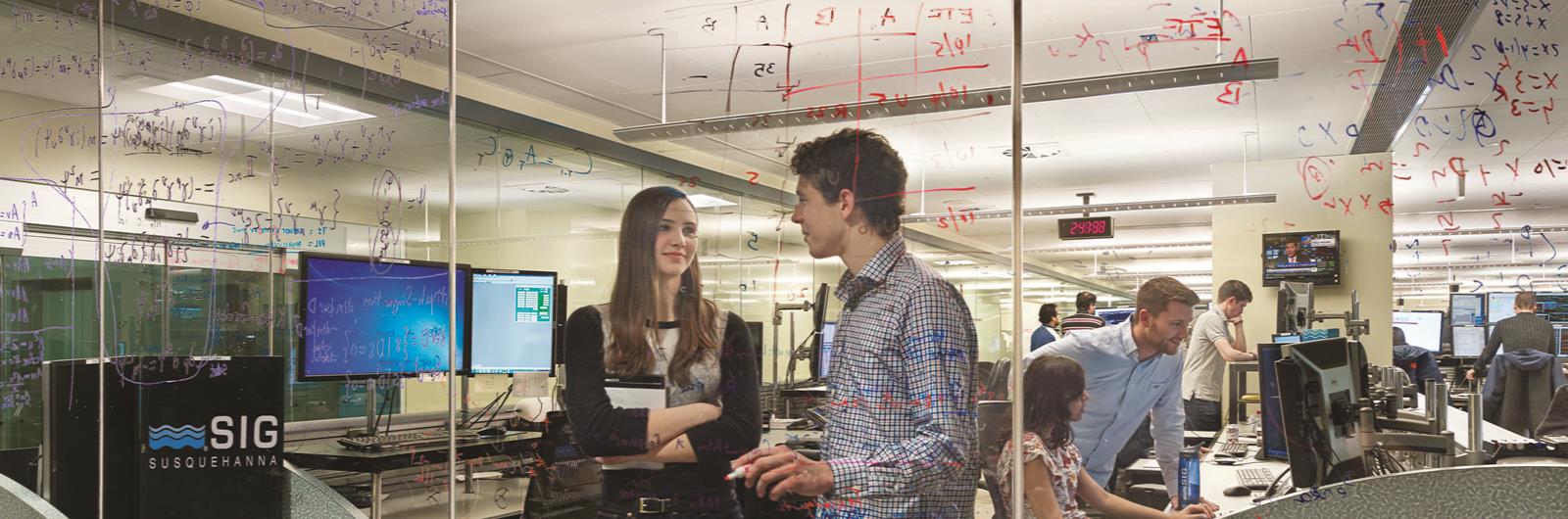 Students working at glass whiteboard