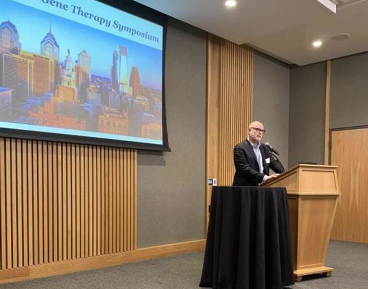 Aleister Saunders presenting at the CGT symposium in front of a projection screen