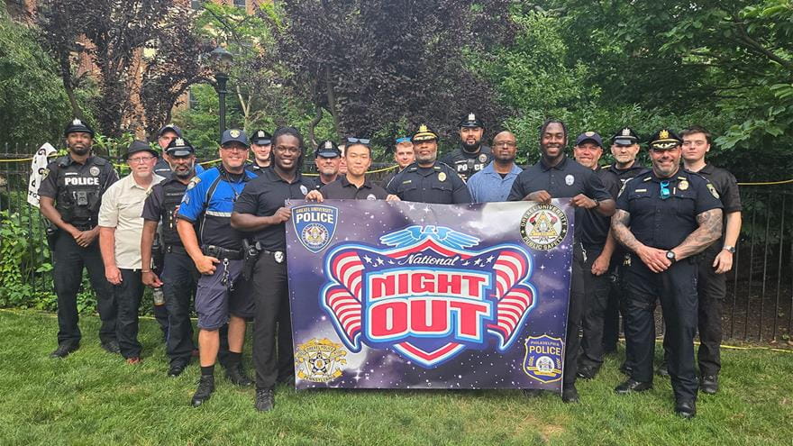 Drexel Public Safety officers holding a National Night Out sign outside.