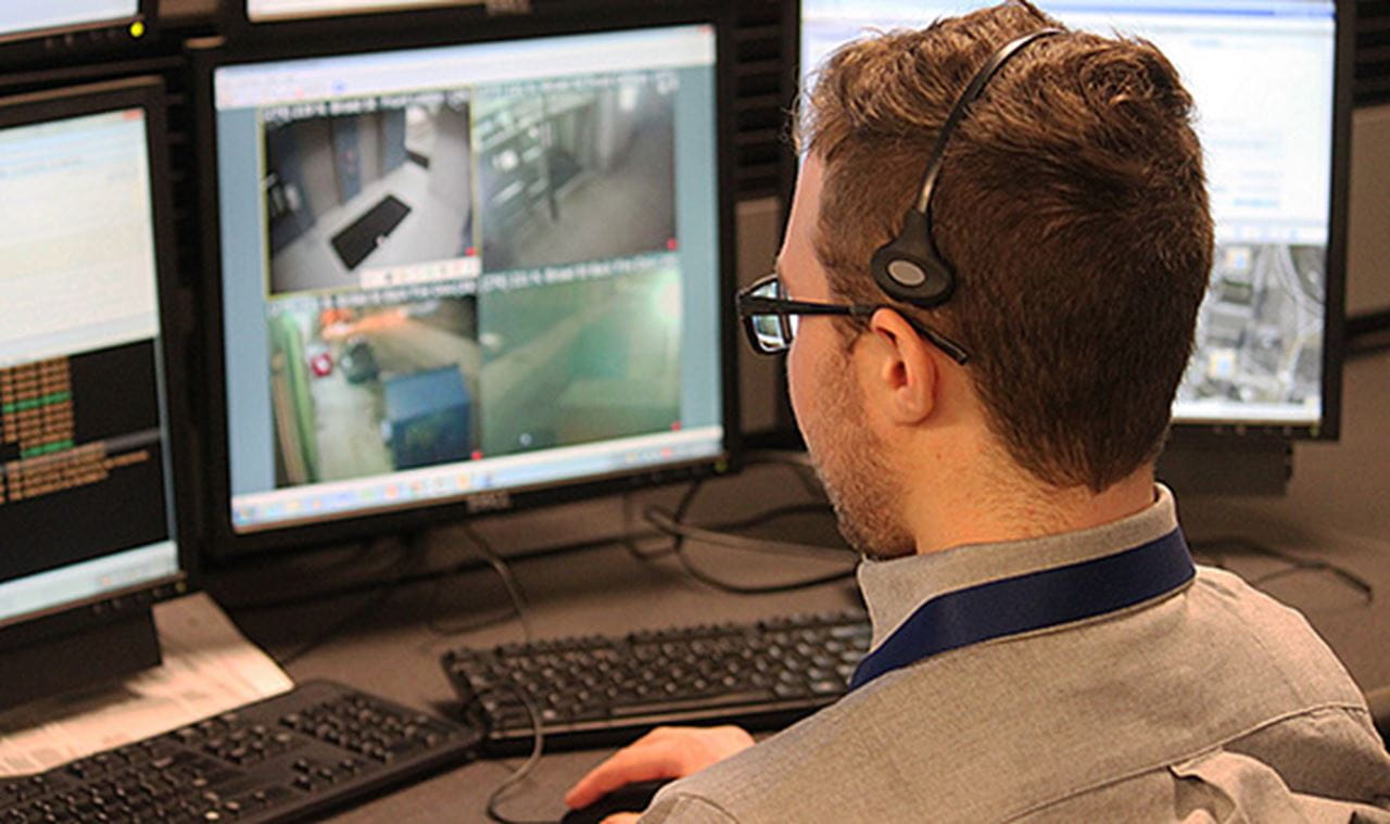 Dispatcher monitors closed-circuit television (CCTV) while wearing headset.