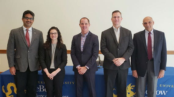 Panel of Experts on Internet of Things standing in front of a table